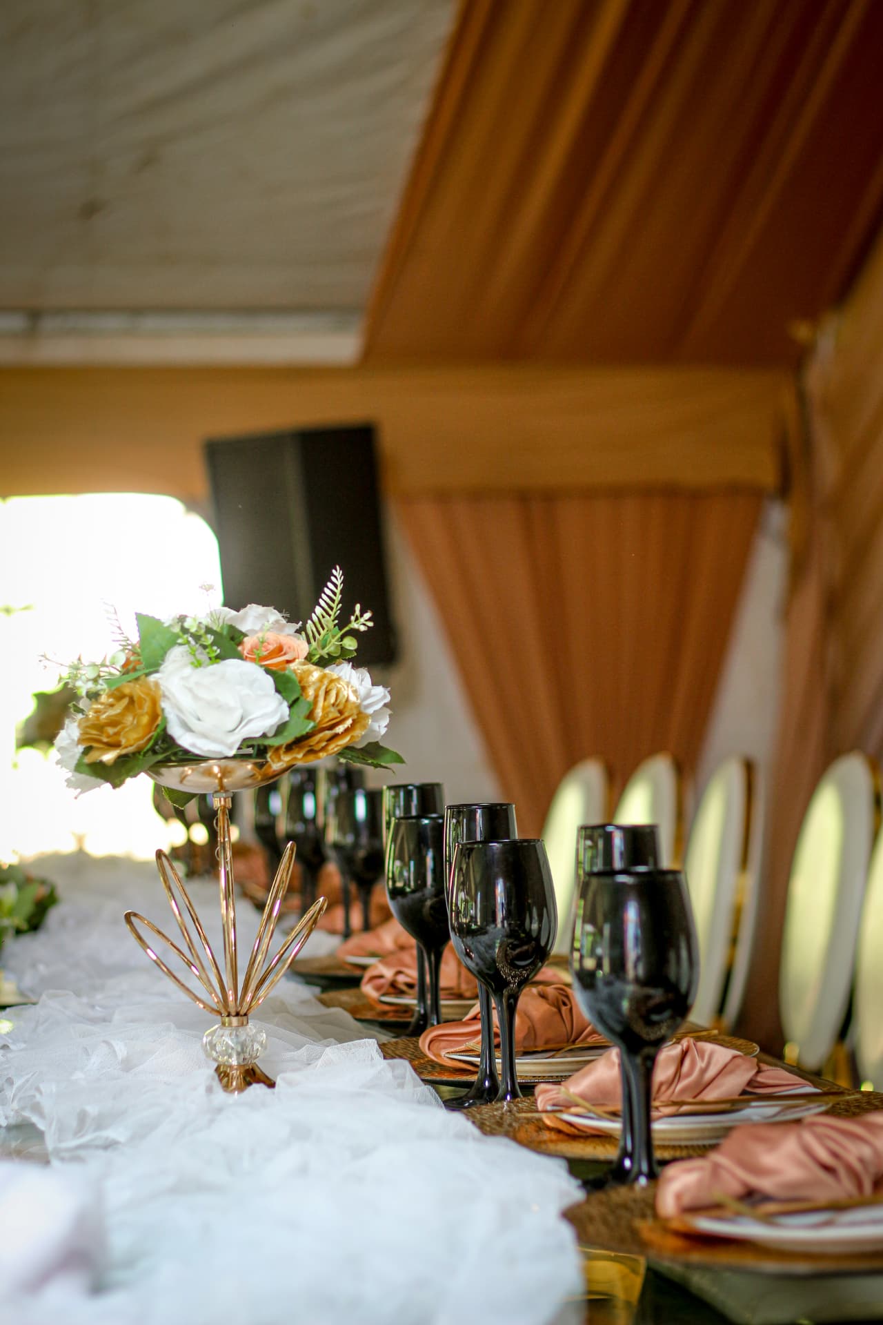 Event table styled with gold chargers, blush napkins and black glassware