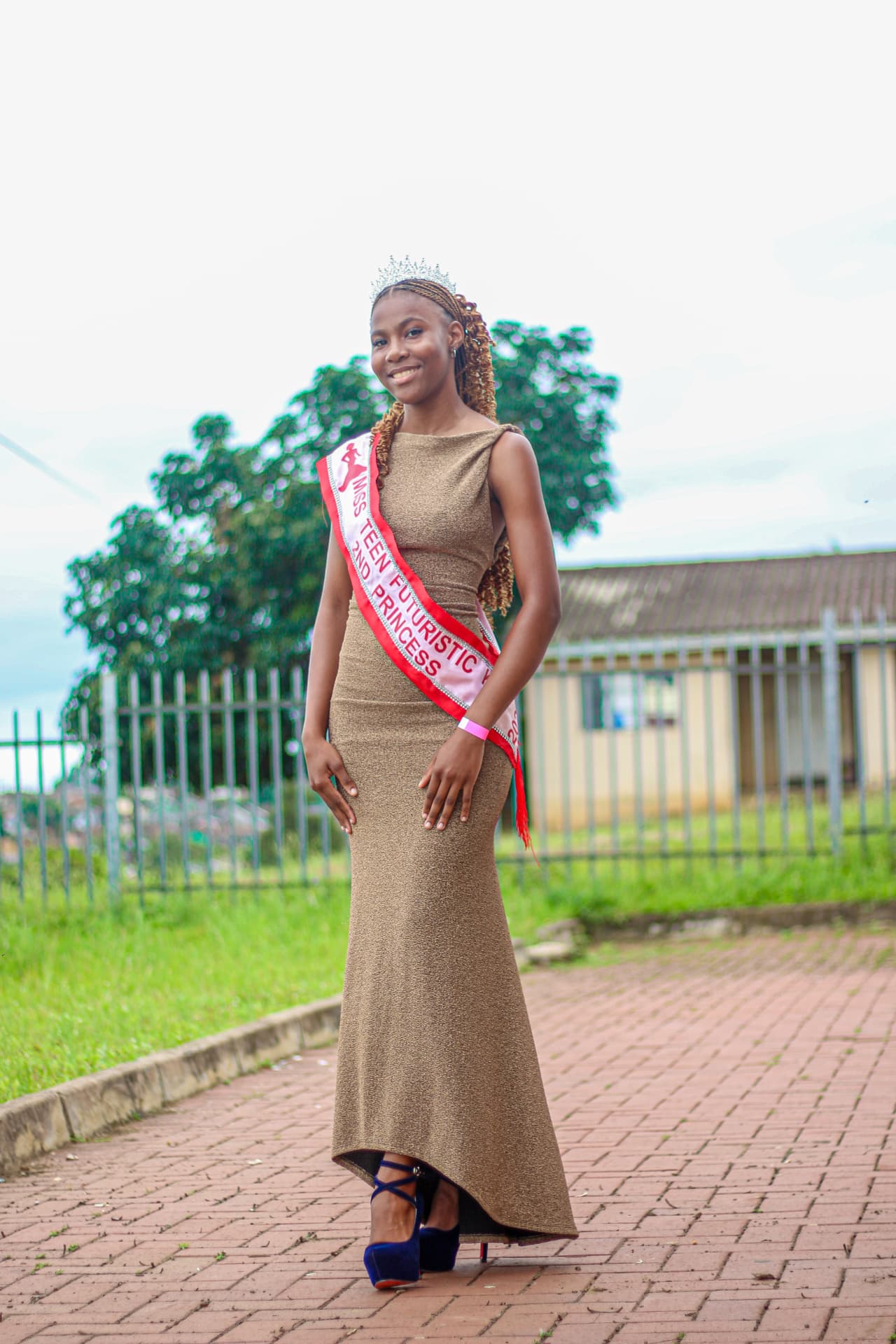 Crowned pageant runner-up in a gold gown wearing a 2nd Princess sash